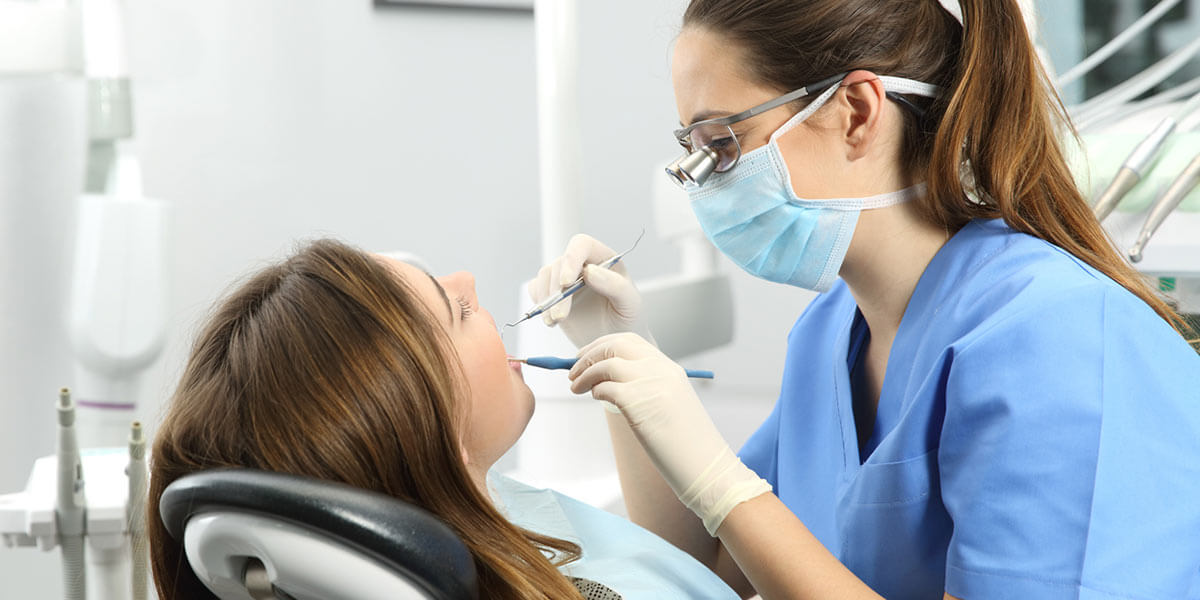 Dentist examining a woman's teeth.