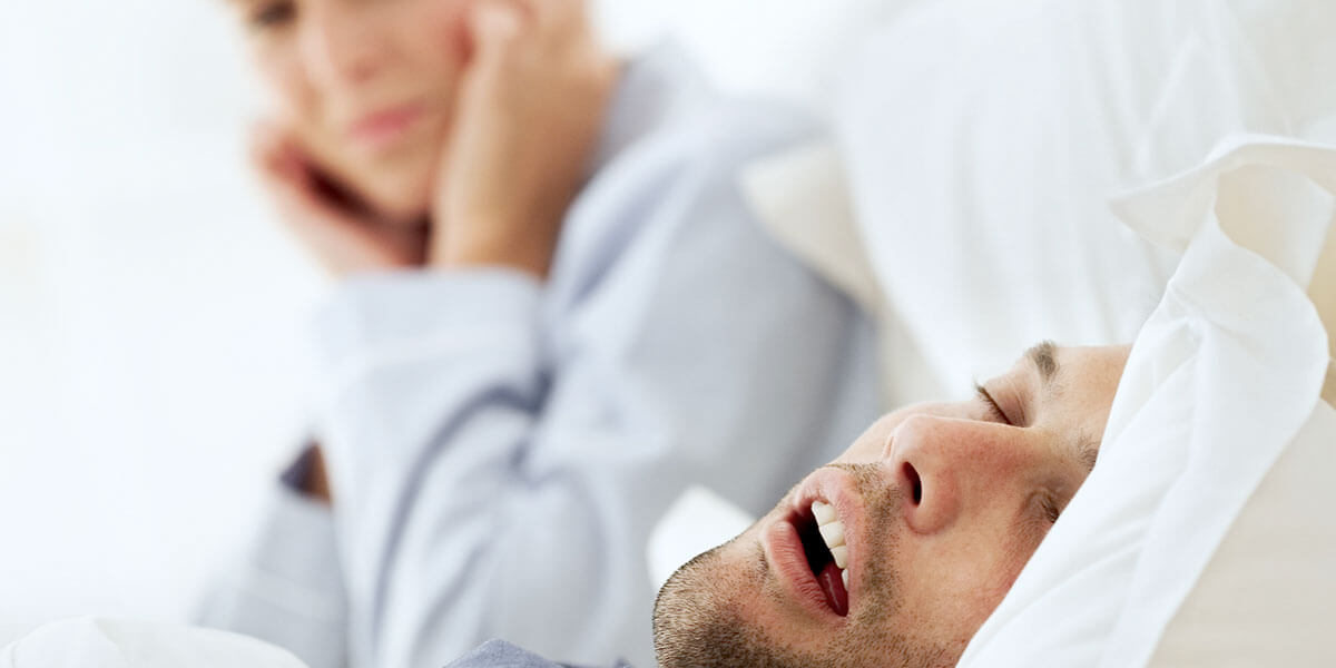 Man with sleep apnea snoring in bed